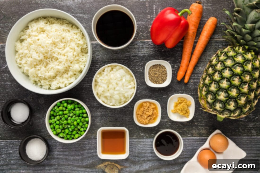 Sun-Kissed Pineapple Rice 4 A collection of fresh ingredients for Pineapple Fried Rice, including diced pineapple, chopped vegetables, and sauces, neatly arranged on a white cutting board.