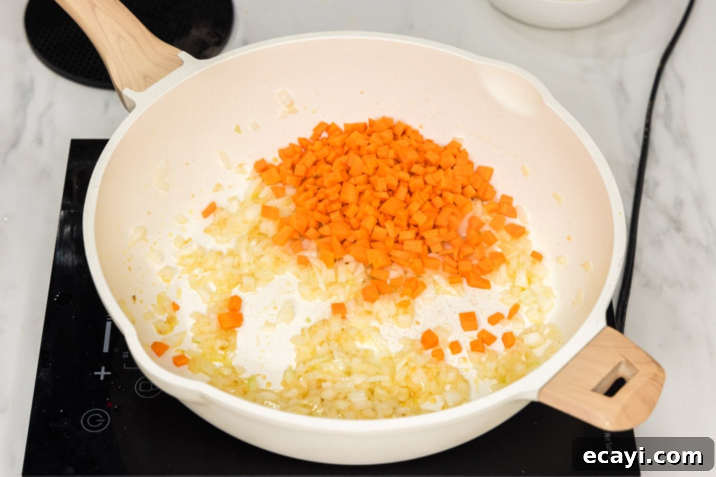 Sun-Kissed Pineapple Rice 6 Diced carrots joining the sautéed onion, garlic, and ginger in the skillet, adding color and flavor to the stir-fry mix.