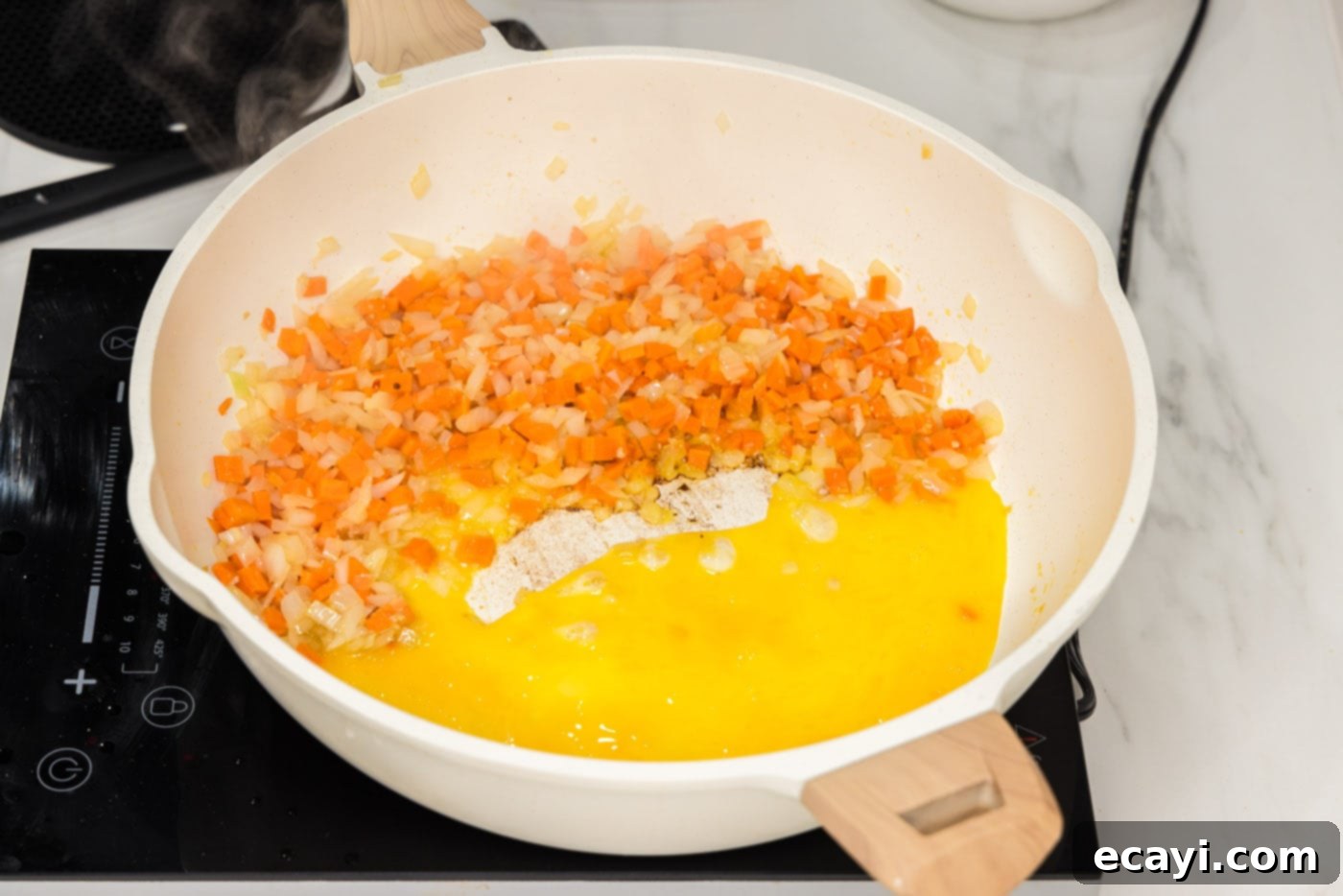 Sun-Kissed Pineapple Rice 7 Whisked eggs being added to one side of the skillet alongside stir-fried vegetables, ready to be scrambled and integrated into the dish.