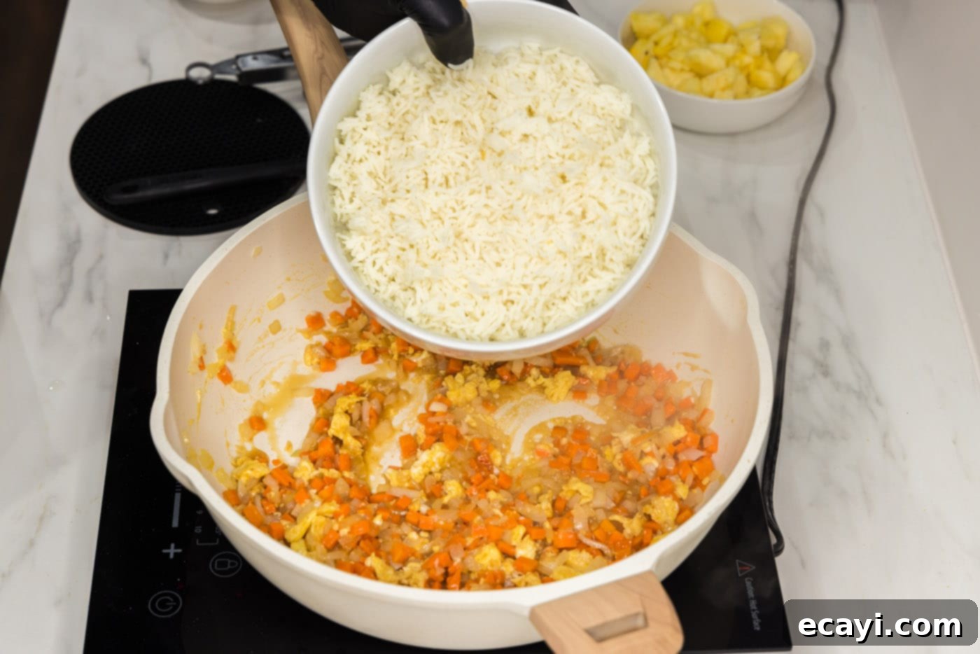 Sun-Kissed Pineapple Rice 10 Cooked white rice freshly added to the pan, mingling with the stir-fried vegetables and scrambled egg, ready for seasoning.