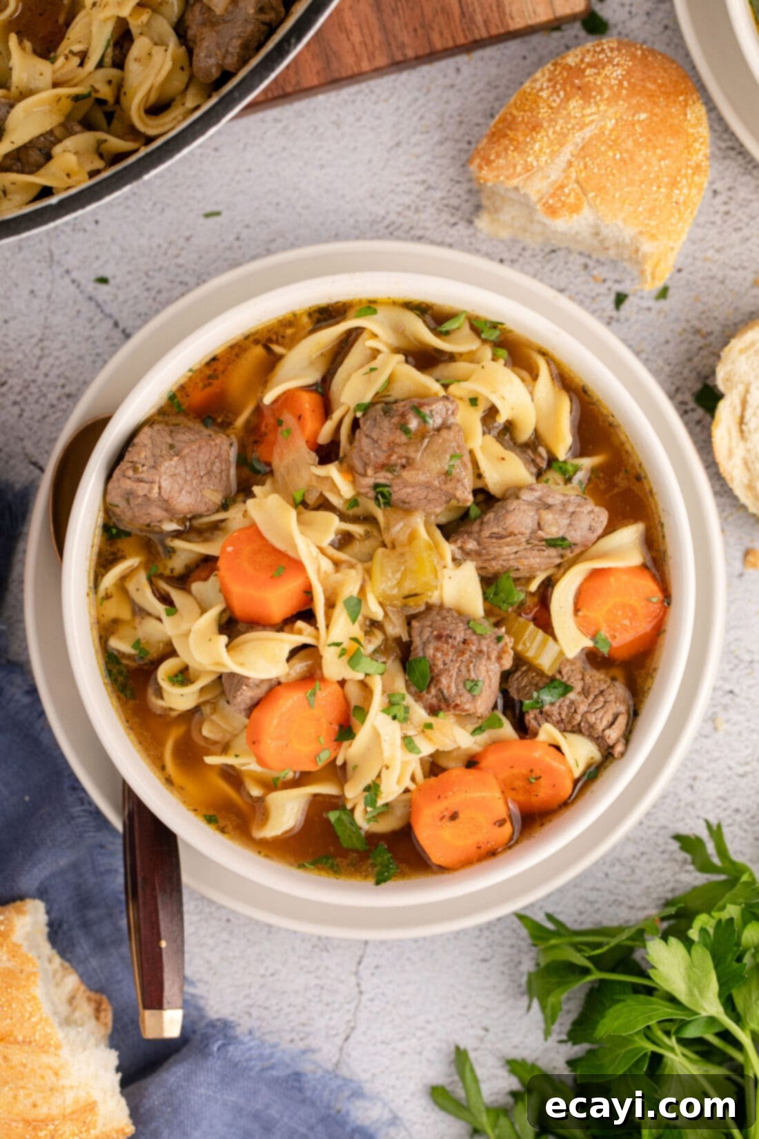 Hearty Beef Noodle Bowl 2 Overhead photo of a steaming bowl of homemade Beef Noodle Soup, garnished with fresh parsley.