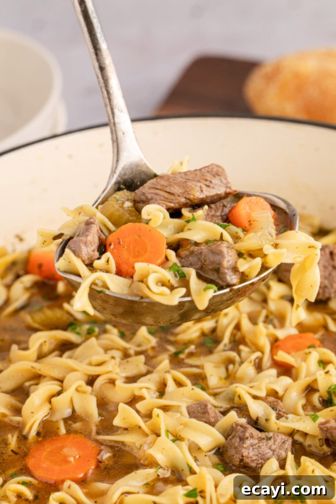 Hearty Beef Noodle Bowl 3 A ladle lifts a scoop of hearty beef noodle soup from a large pot, showing tender beef, vegetables, and noodles.