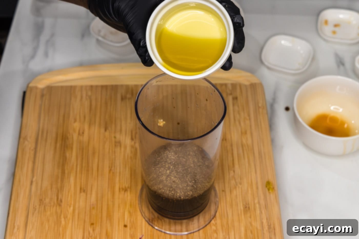 Mushroom Burger 5 pouring olive oil into marinade in an immersion blender