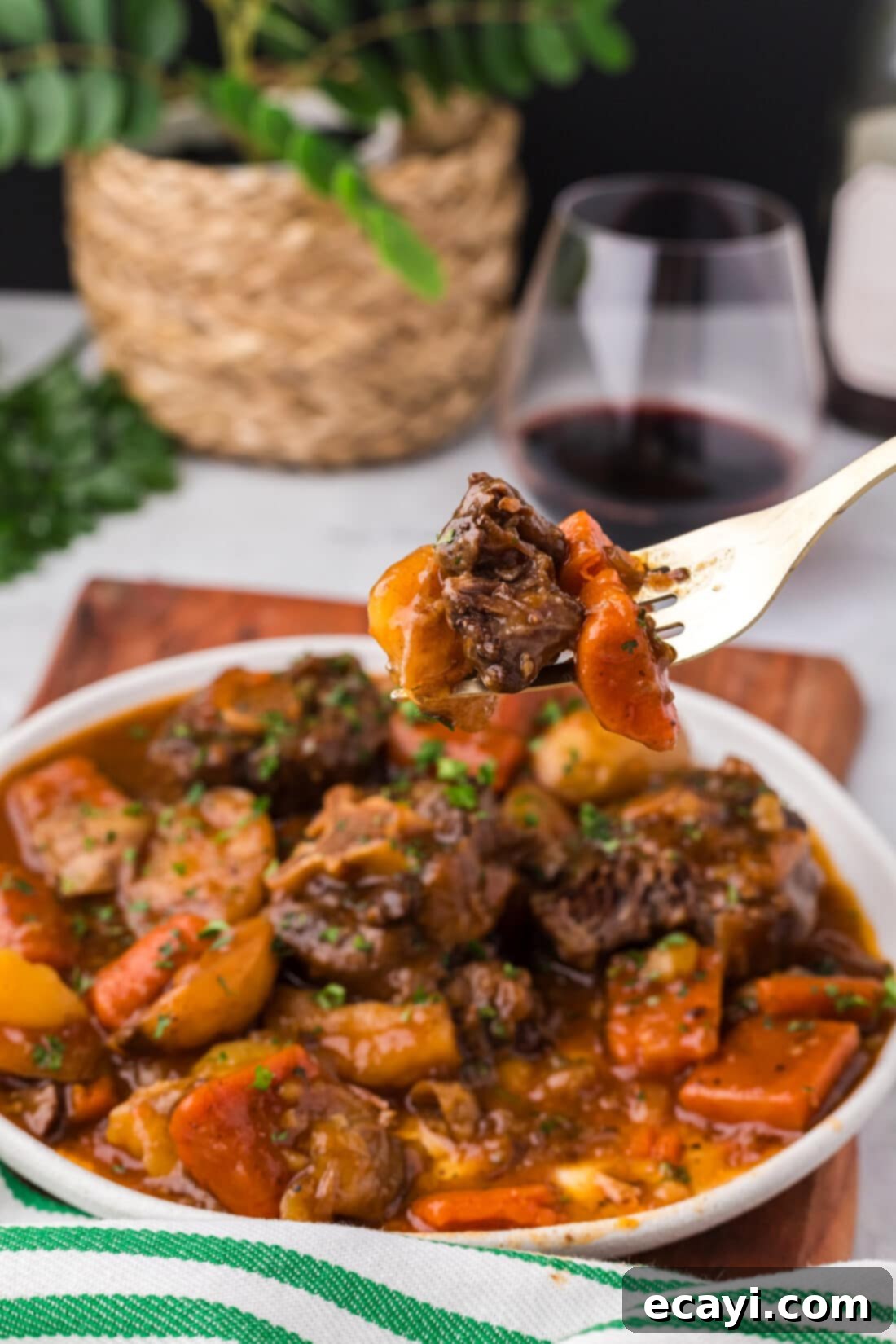 Instant Pot Fall-Off-The-Bone Oxtail 11 Instant Pot Oxtail on a fork held above a plate of Instant Pot Oxtail