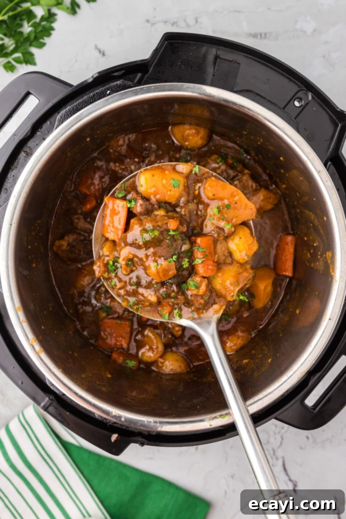 Instant Pot Fall-Off-The-Bone Oxtail 3 Serving spoon holding Instant Pot Oxtail over an Instant Pot