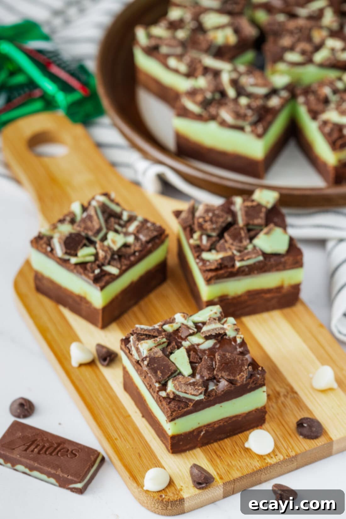 Irresistible Andes Mint Fudge 3 Three squares of Andes Mint Fudge on a wooden board