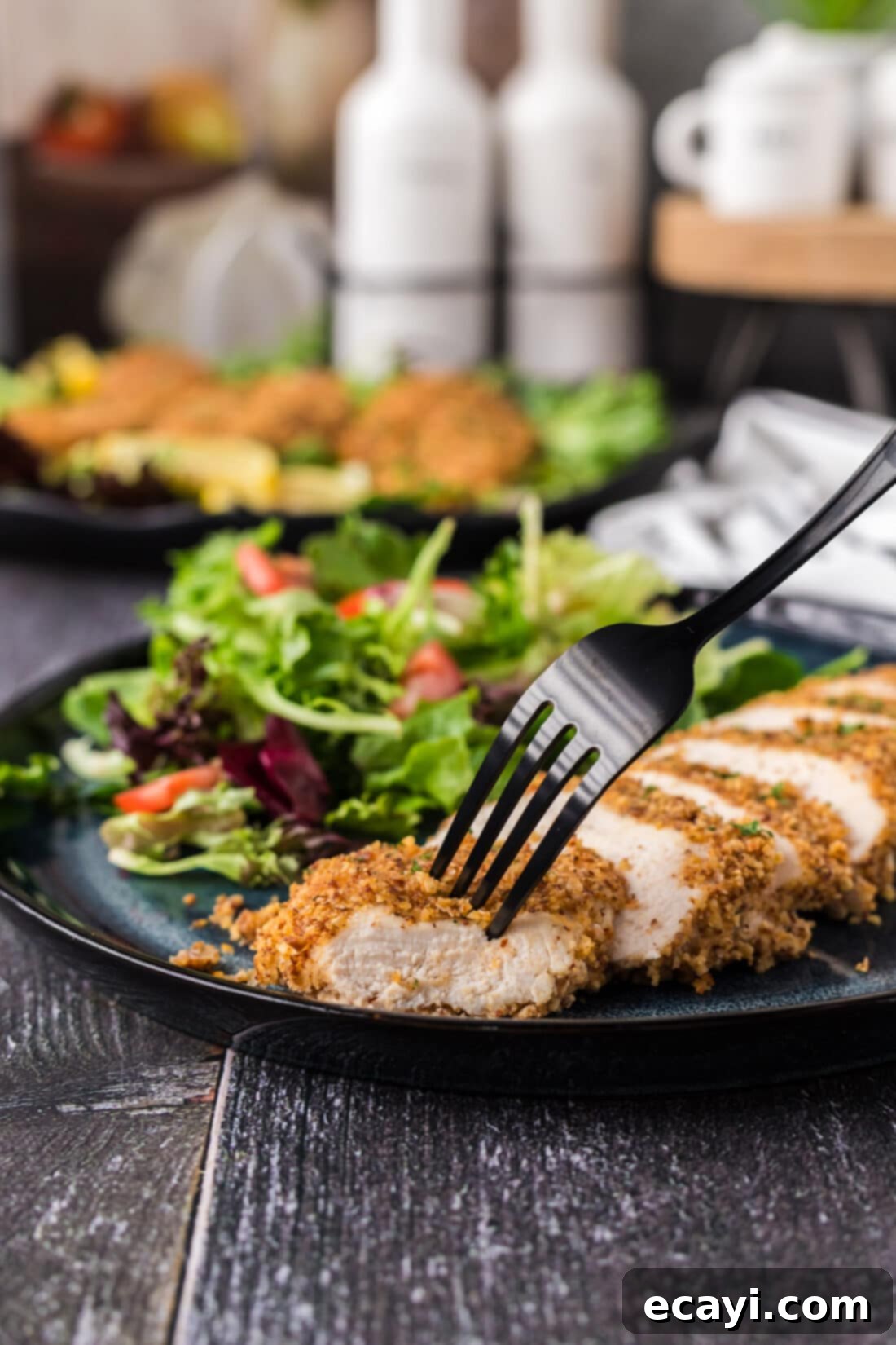 Golden Almond Chicken 12 Fork in a piece of Almond Crusted Chicken with salad on the side