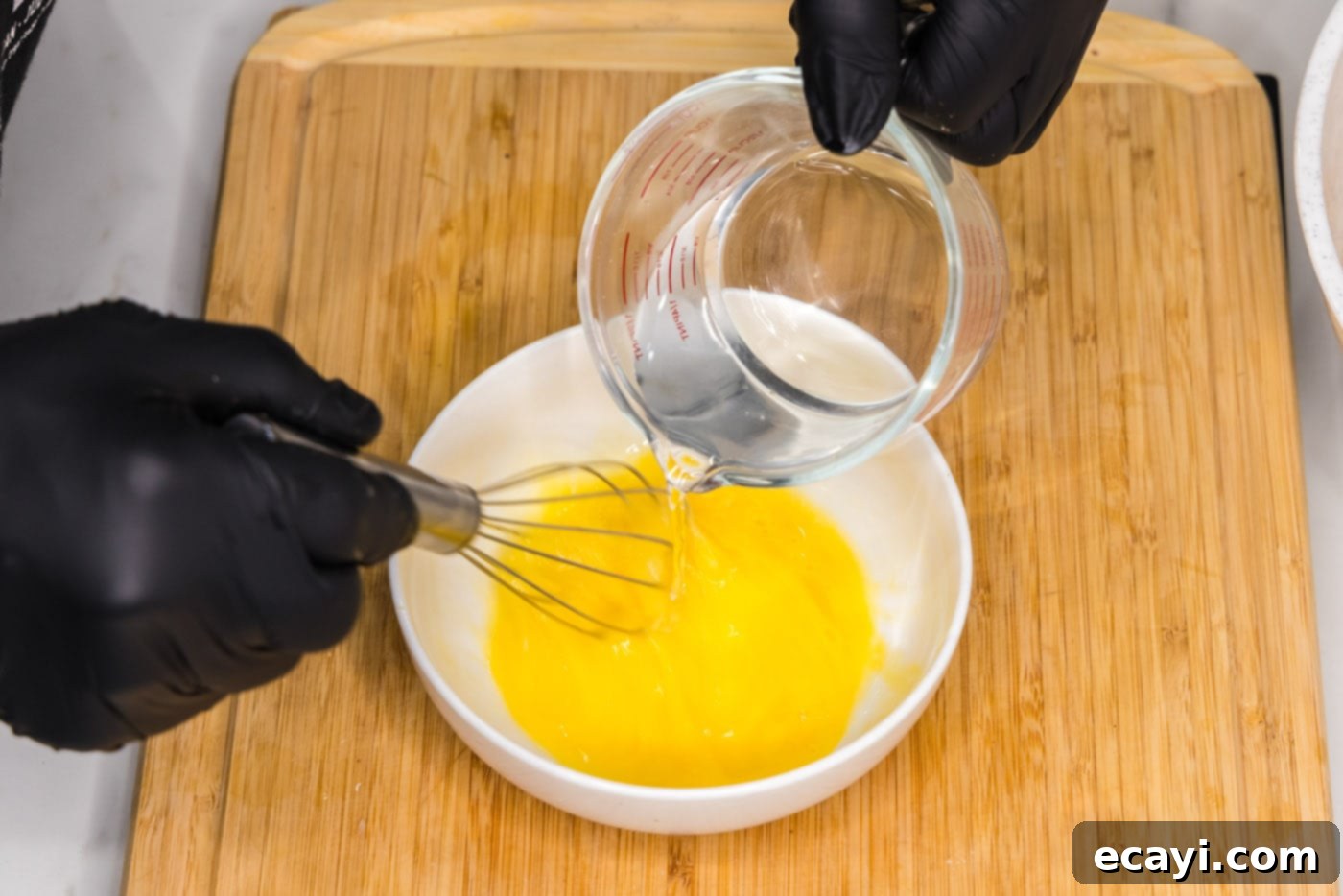 Golden Almond Chicken 7 whisking egg with water in a bowl