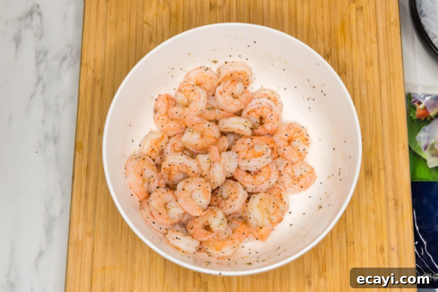 Hand-Rolled Shrimp Delights 6 cooked shrimp seasoned with garlic salt and pepper in a mixing bowl