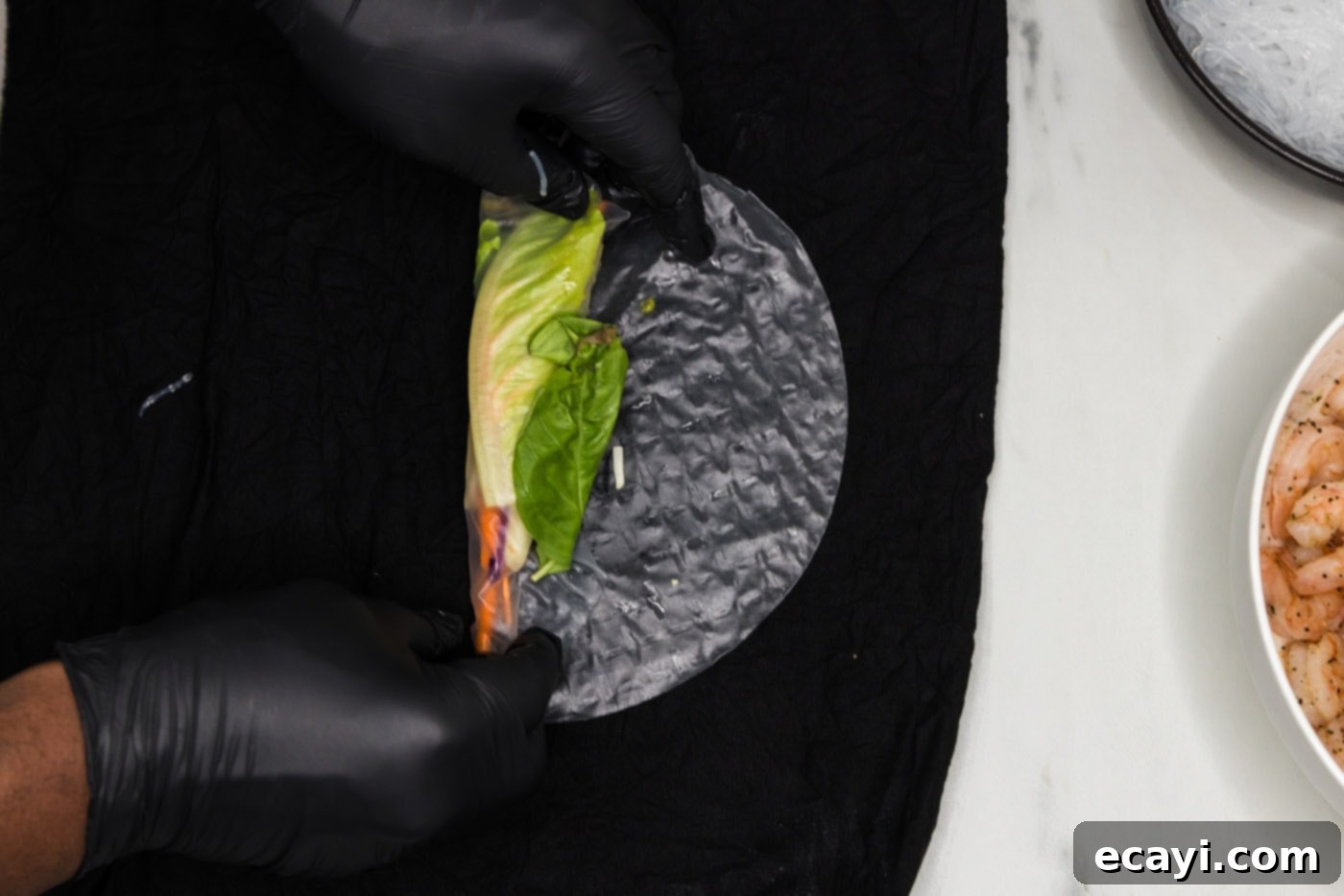 Hand-Rolled Shrimp Delights 9 wrapping vegetables in a spring roll wrapper halfway, then adding basil leaves