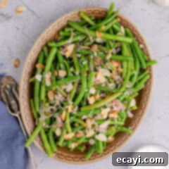 Almond-Kissed Crisp Green Beans 14 Close up photo of Green Beans Almondine in a serving platter with a double white border and rounded edges, highlighting the finished dish.