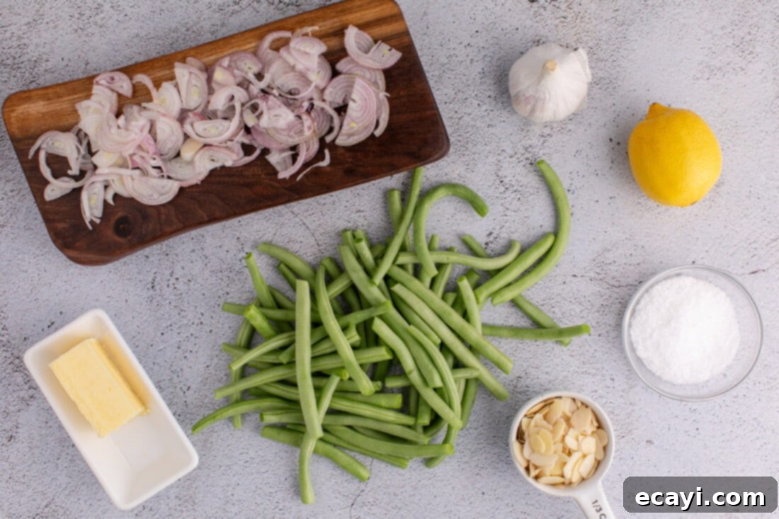 Almond-Kissed Crisp Green Beans 4 Ingredients for Green Beans Almondine laid out: fresh green beans, sliced almonds, butter, shallots, garlic, lemon, and sea salt.