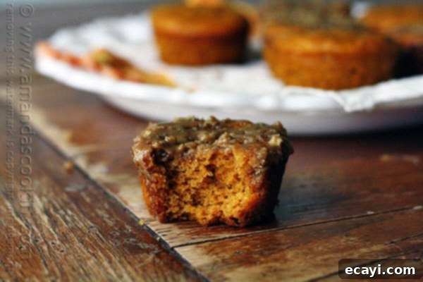 Cozy Pumpkin Mini Cakes with Cinnamon Streusel 3 A close up photo of a half eaten pumpkin mini cake with cinnamon streusel topping.