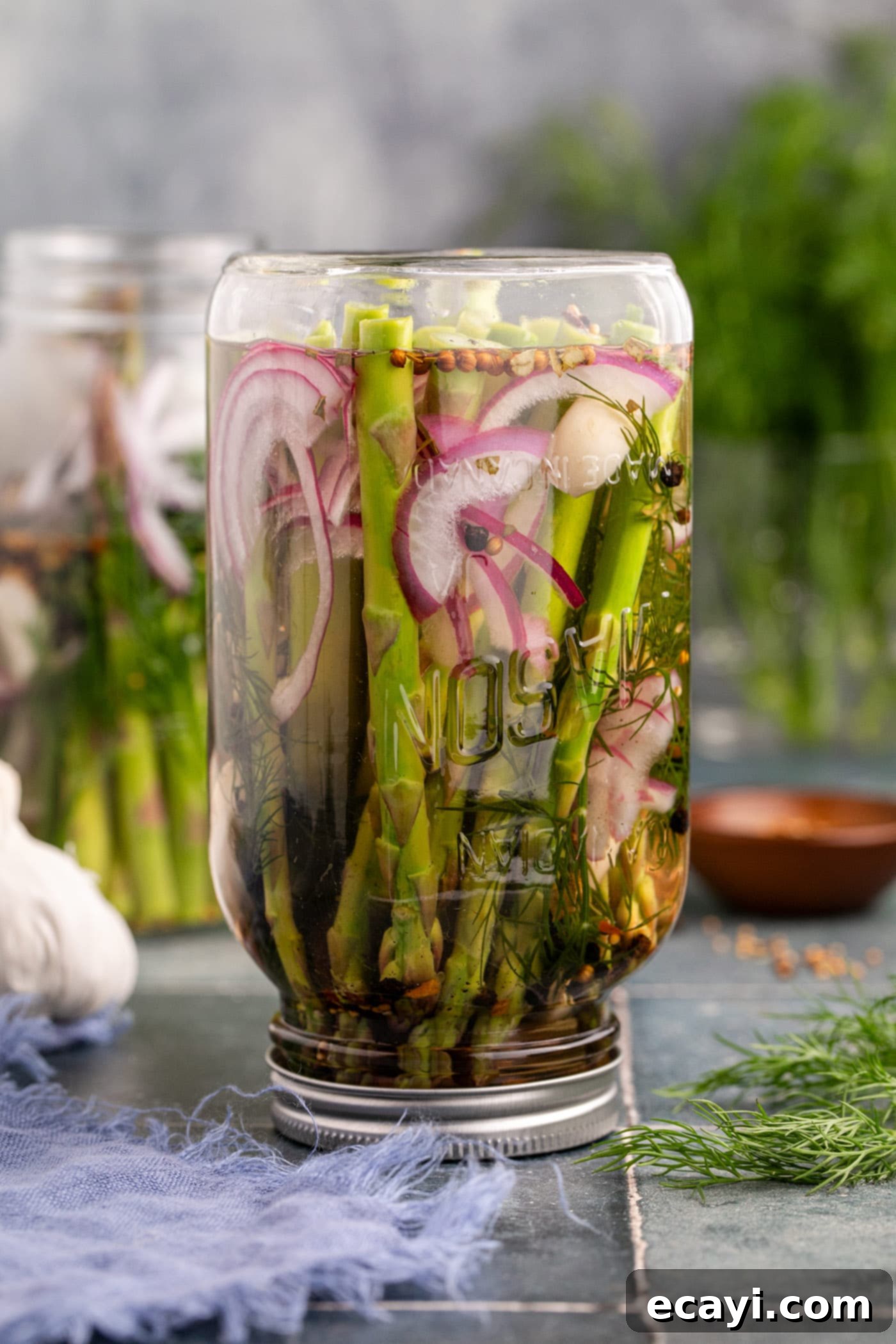 Tangy Asparagus Spears 5 pickled asparagus upside down in a mason jar