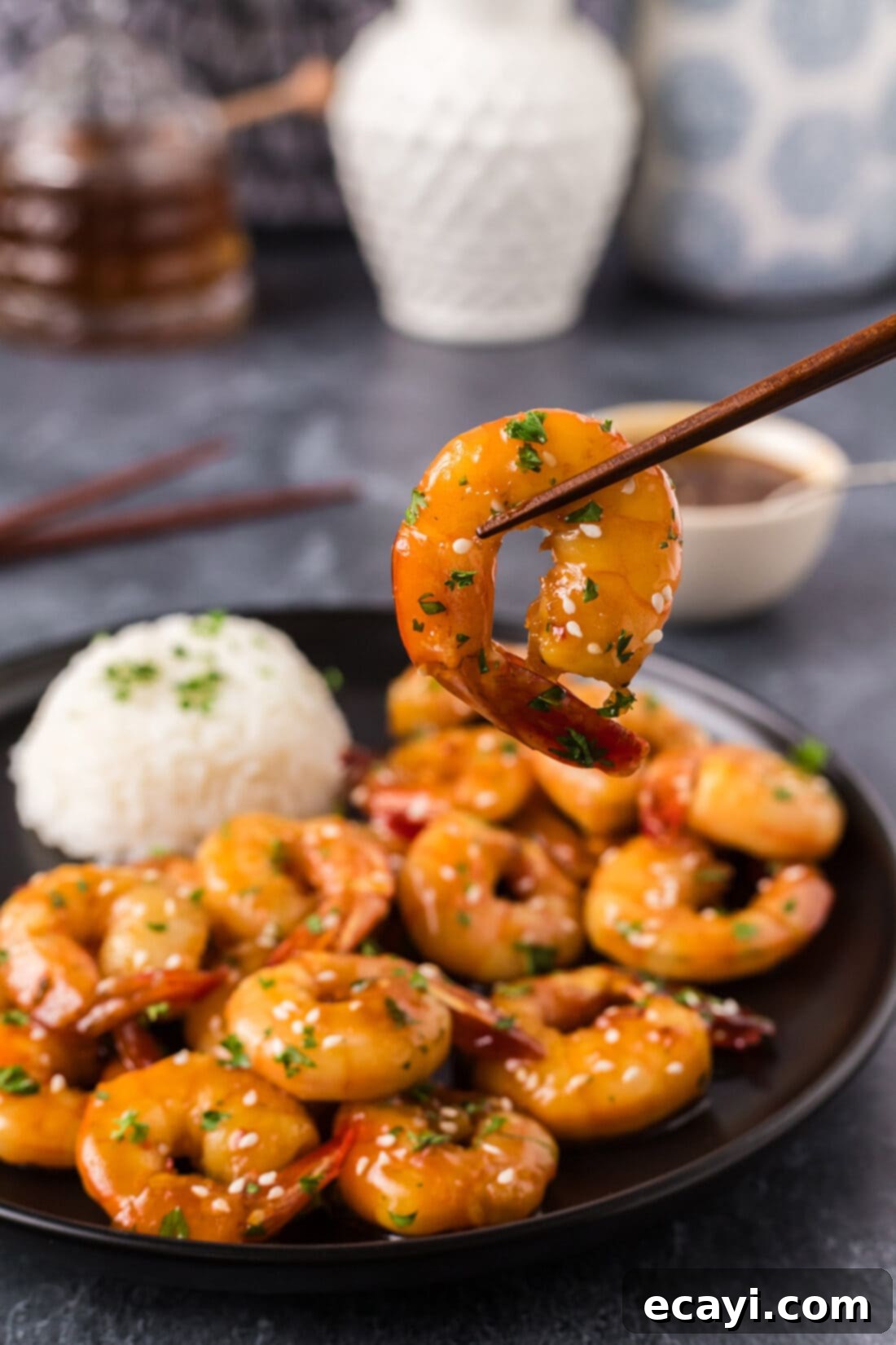 Glazed Honey Garlic Shrimp 3 Honey Garlic Shrimp held gracefully by chopsticks, showcasing the shiny glaze