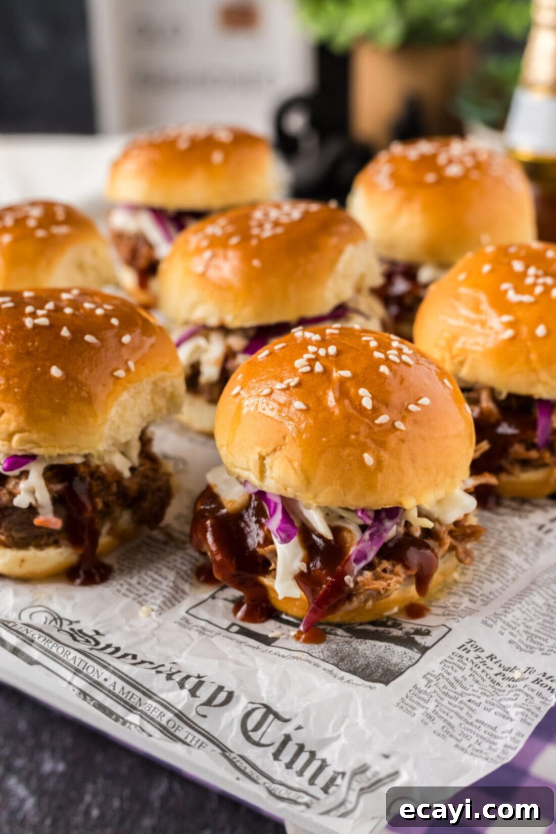 BBQ Pulled Pork Bites 6 Pulled Pork Sliders on parchment paper, arranged beautifully and ready to be enjoyed as a snack or meal