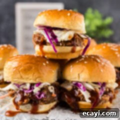 BBQ Pulled Pork Bites 7 Stack of freshly assembled Pulled Pork Sliders, topped with coleslaw and ready to serve