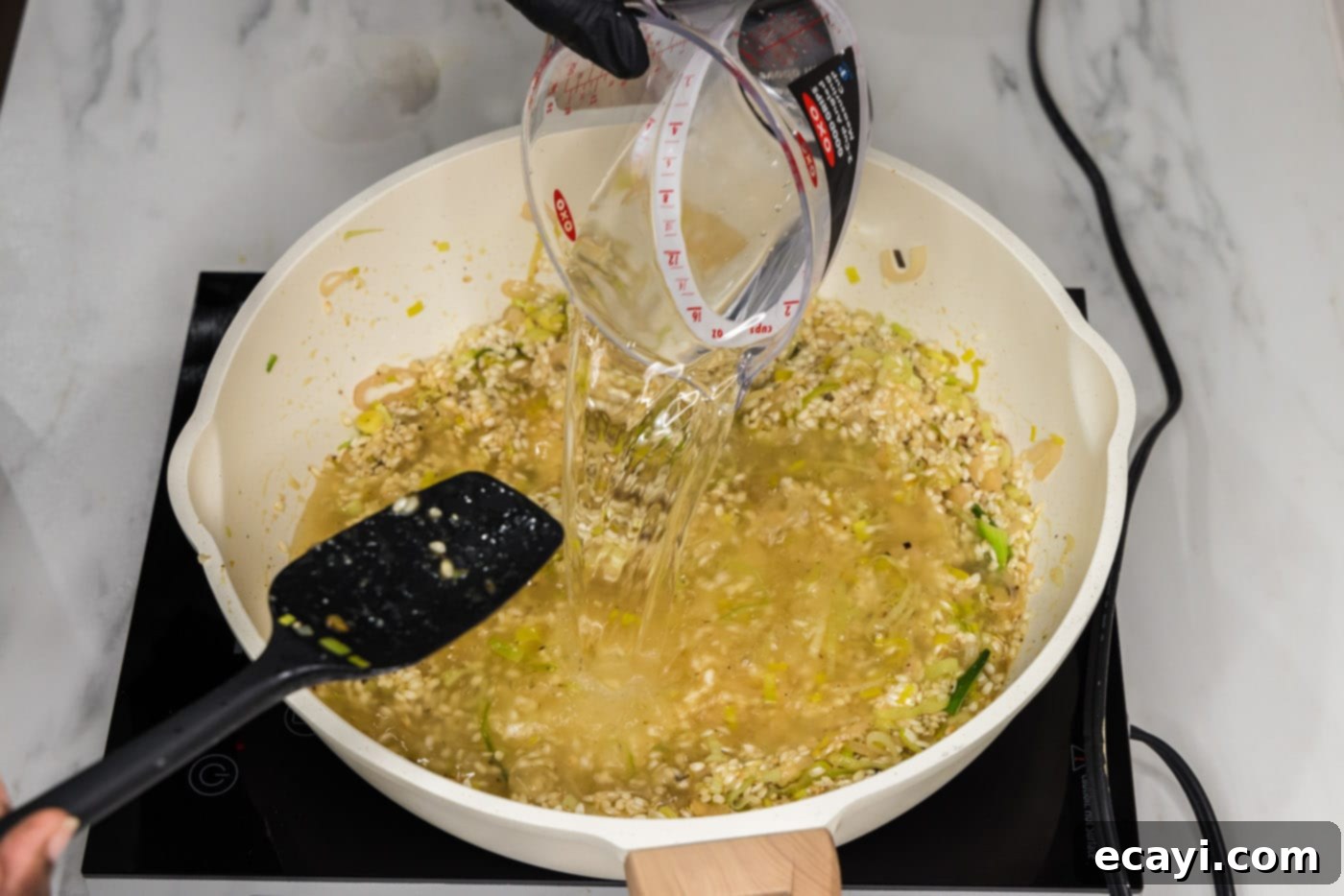 Velvet Asparagus Risotto 12 pouring water into risotto in a skillet