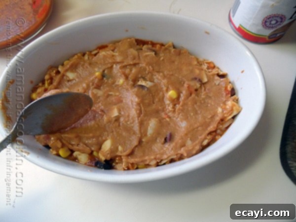 Golden Chicken Tostada Bake 6 A smooth, even layer of rich refried beans spread over the chicken and tortillas, building the next delightful tier of the casserole.