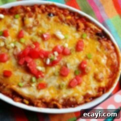 Golden Chicken Tostada Bake 9 An overhead photo of a chicken tostada casserole with chopped green onions and tomatoes on top, ready to be served.