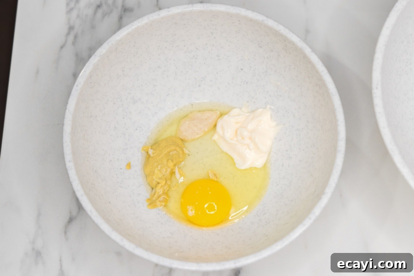 Crispy Fish Sandwich 5 egg, horseradish, mayonnaise, and Dijon mustard in a bowl, being whisked together