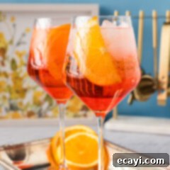 Golden Hour Aperol Spritz 9 Two vibrant Aperol Spritz cocktails on a serving platter, inviting you to enjoy a refreshing moment.