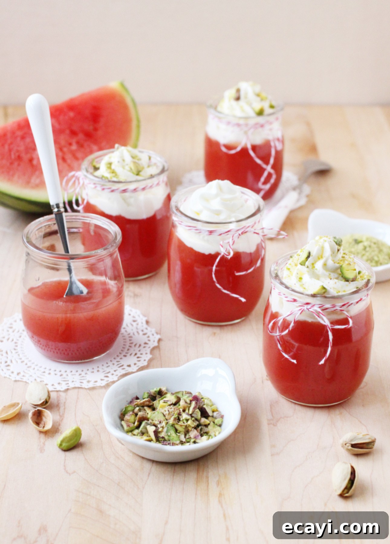 Sicilian Summer Watermelon Dream 4 Three glass jars of Sicilian Watermelon Pudding ready to serve, garnished with whipped cream and pistachios