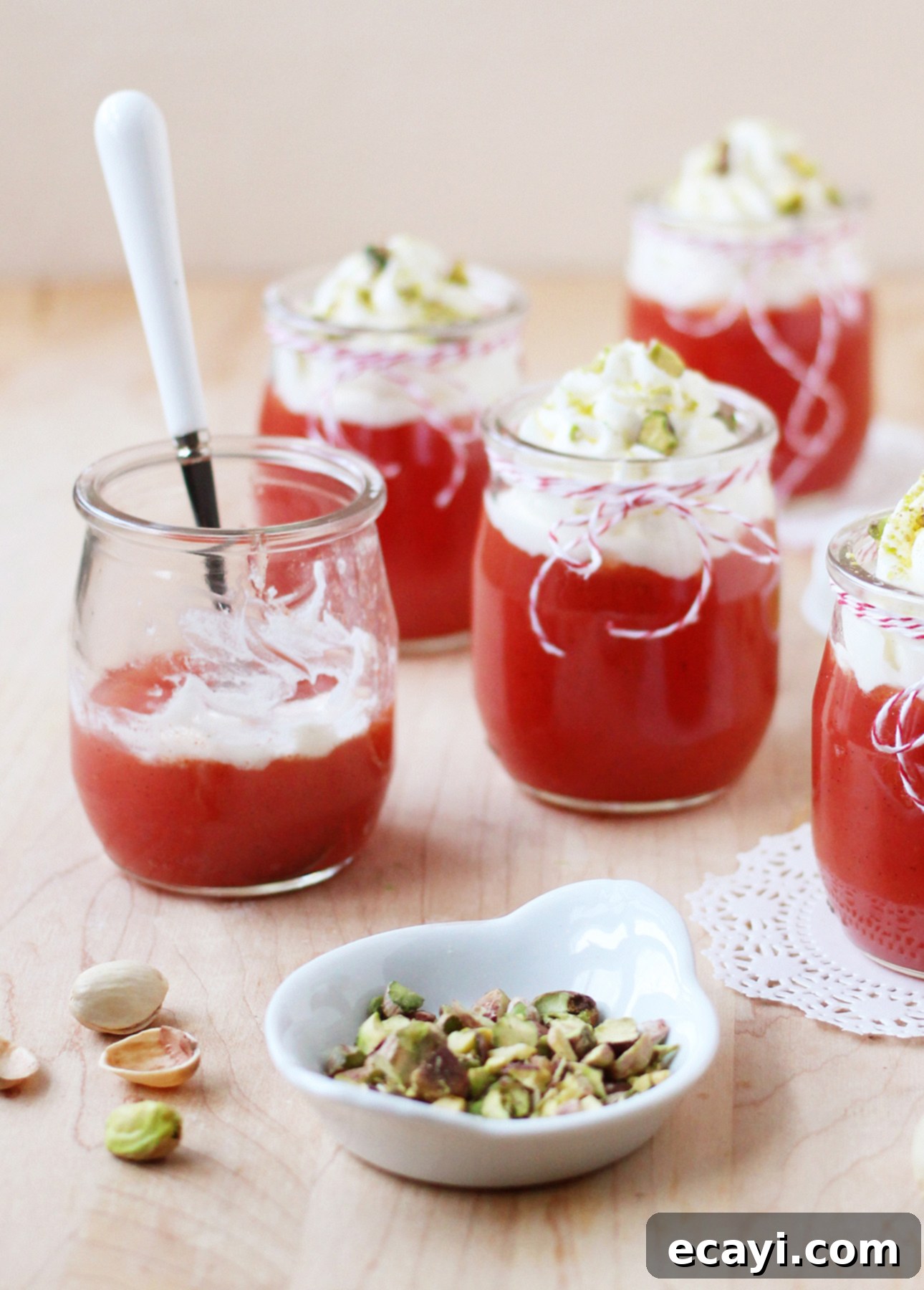 Sicilian Summer Watermelon Dream 5 A single portion of Sicilian Watermelon Pudding in a glass jar, topped with whipped cream and pistachios