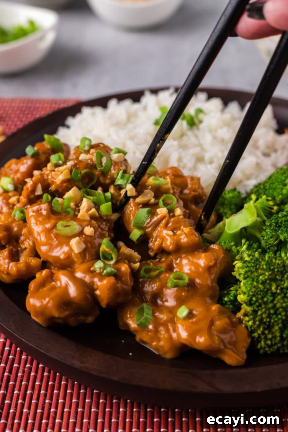 Creamy Peanut Butter Chicken 3 Chopsticks picking up a delectable piece of Peanut Butter Chicken, showing its glaze