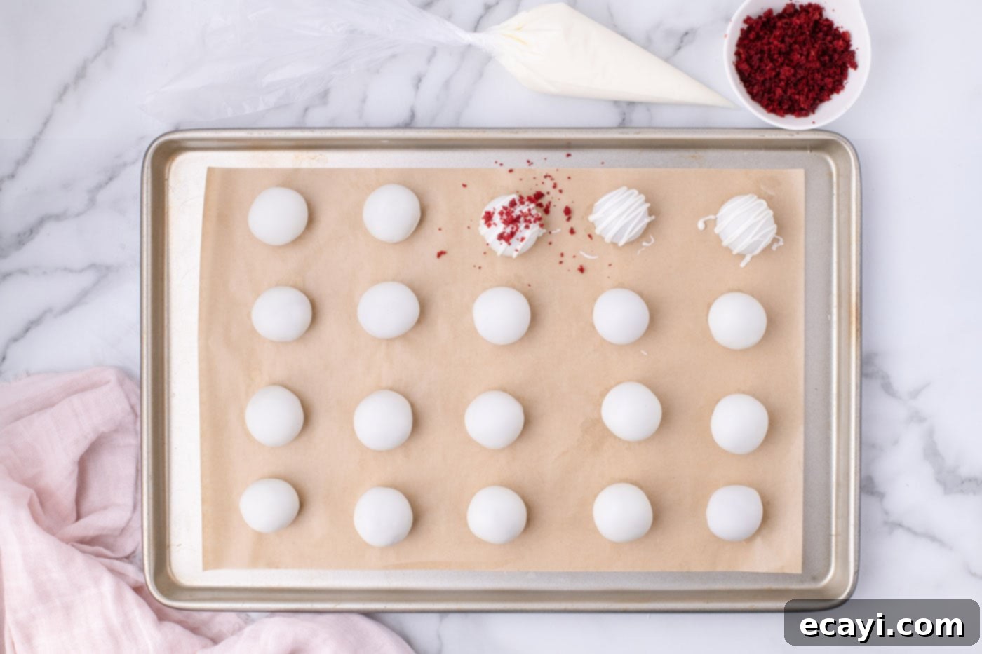 Red Velvet Truffles 13 Hand sprinkling red velvet cake crumbs onto white chocolate-coated red velvet cake balls.