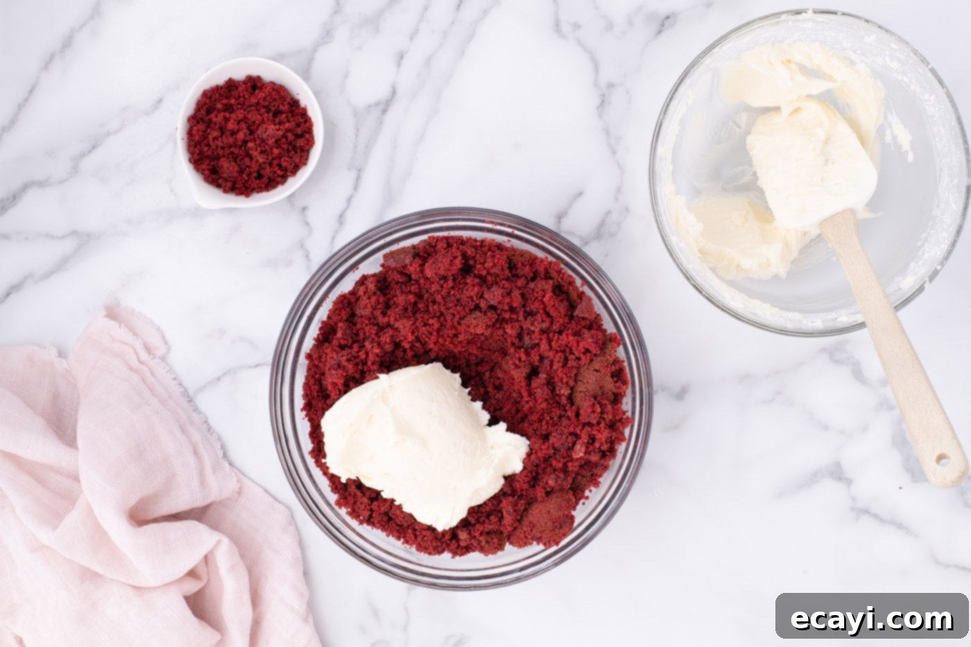 Red Velvet Truffles 10 A large mixing bowl containing crumbled red velvet cake with cream cheese frosting added, being mixed with a spatula.