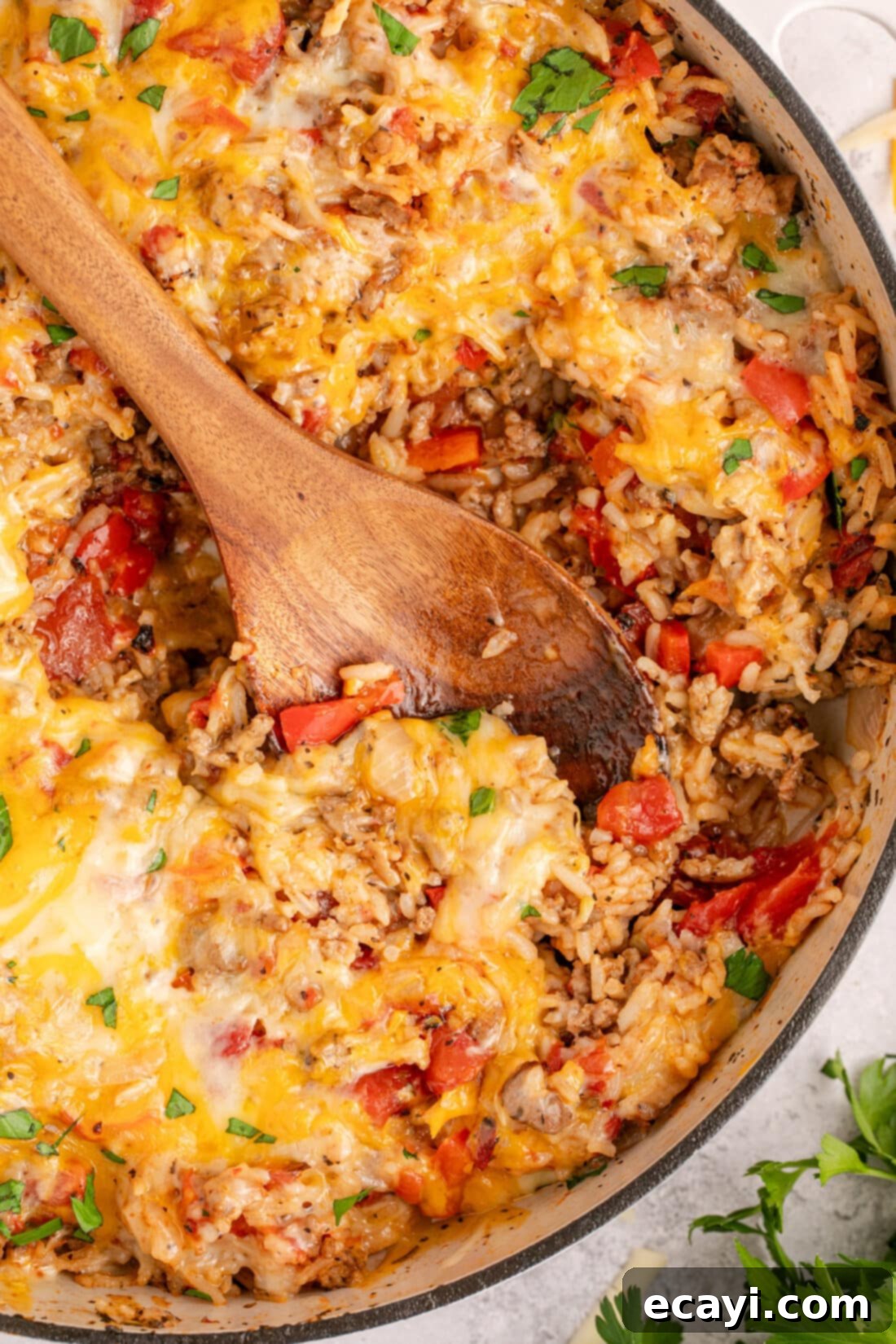 Deconstructed Stuffed Pepper Bake 3 A large serving spoon resting in a Dutch oven brimming with golden-brown, cheesy Stuffed Pepper Casserole, ready to be served.
