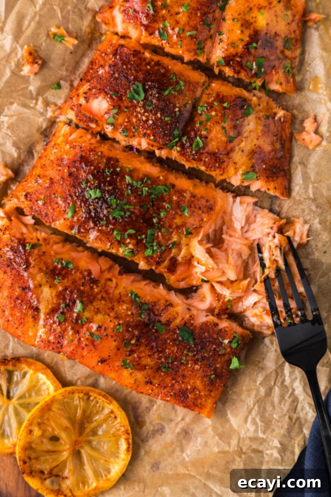 Artisan Smoked Salmon 2 A fork gently pulls apart a perfectly cooked, flaky filet of Smoked Salmon, showcasing its tender texture.