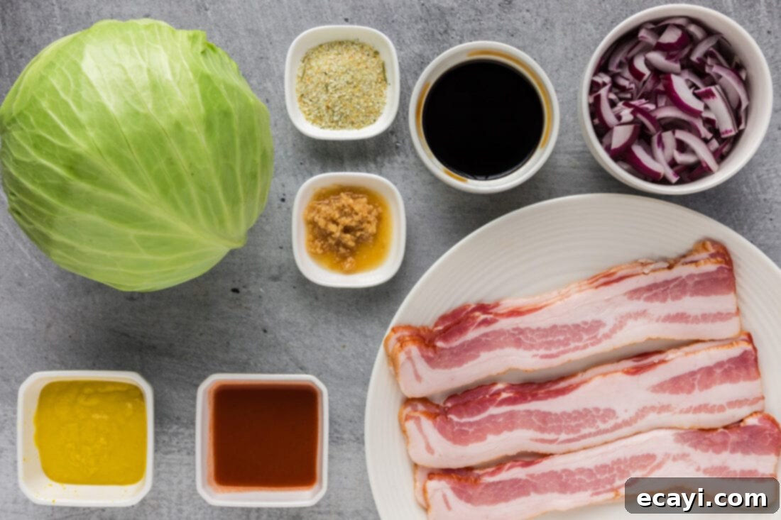 Sizzling Spicy Cabbage 4 A flat lay photograph of all the ingredients for spicy fried cabbage laid out on a kitchen counter: chopped bacon, red onion, garlic, mustard, soy sauce, hot sauce, and a head of green cabbage.
