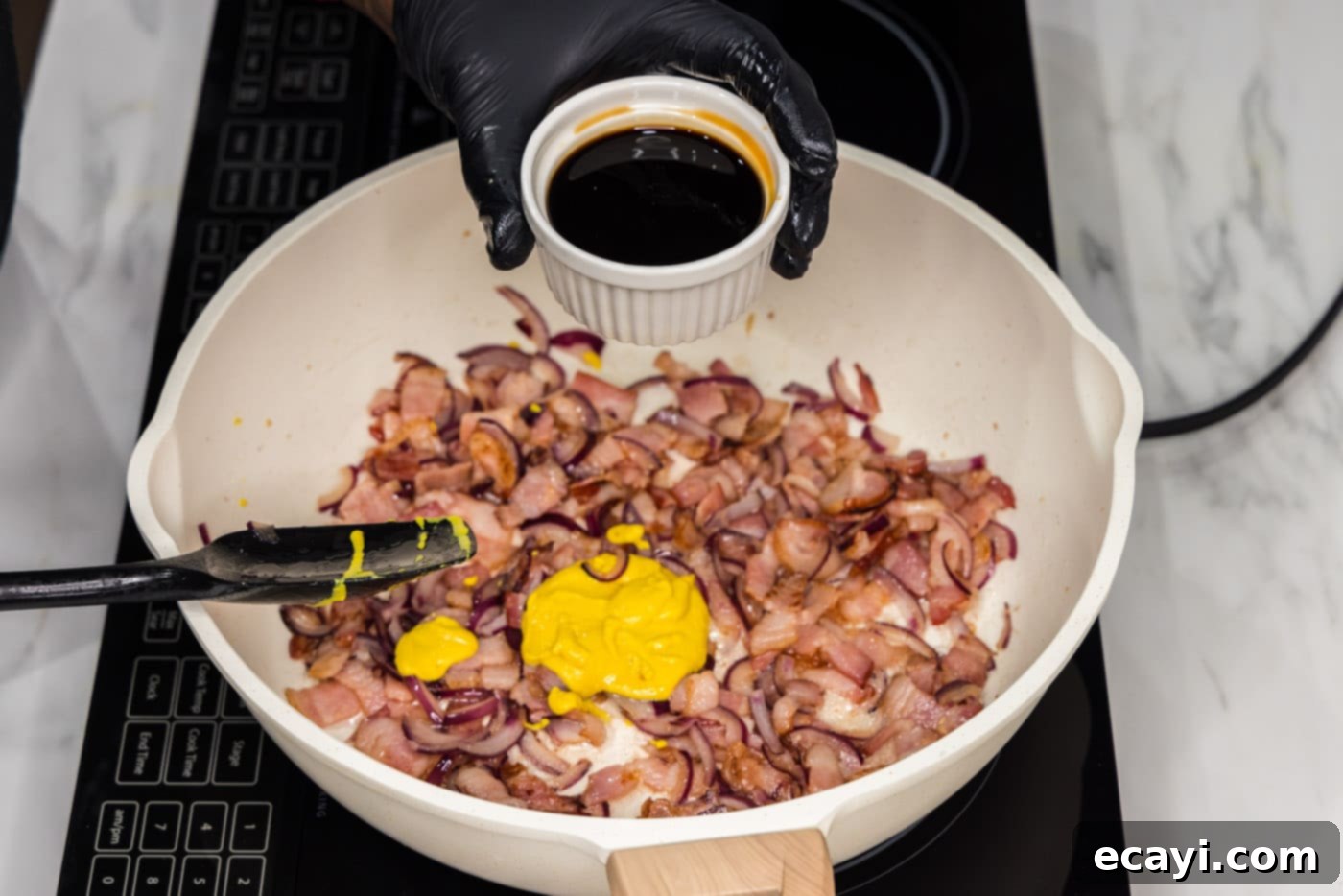 Sizzling Spicy Cabbage 5 Adding low sodium soy sauce to the skillet with cooked bacon, red onion, and garlic, forming the sauce base.
