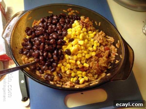 Fiesta Rice with Black Beans and Corn 7 A bowl of Spanish rice with black beans and corn on top.