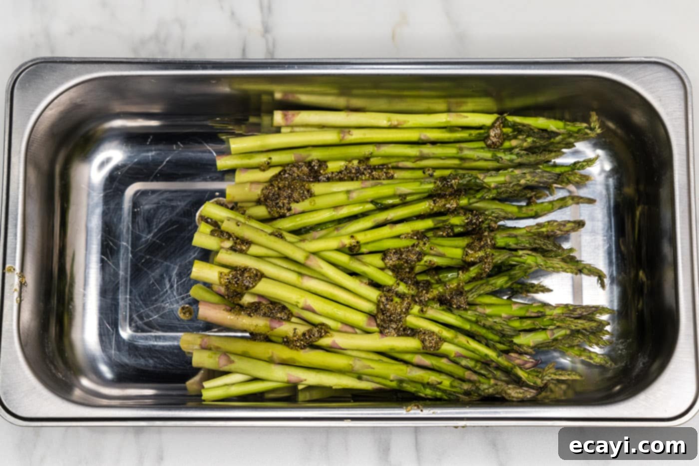 Perfectly Steamed Asparagus 6 Fresh asparagus spears coated with olive oil and seasonings in a mixing bowl