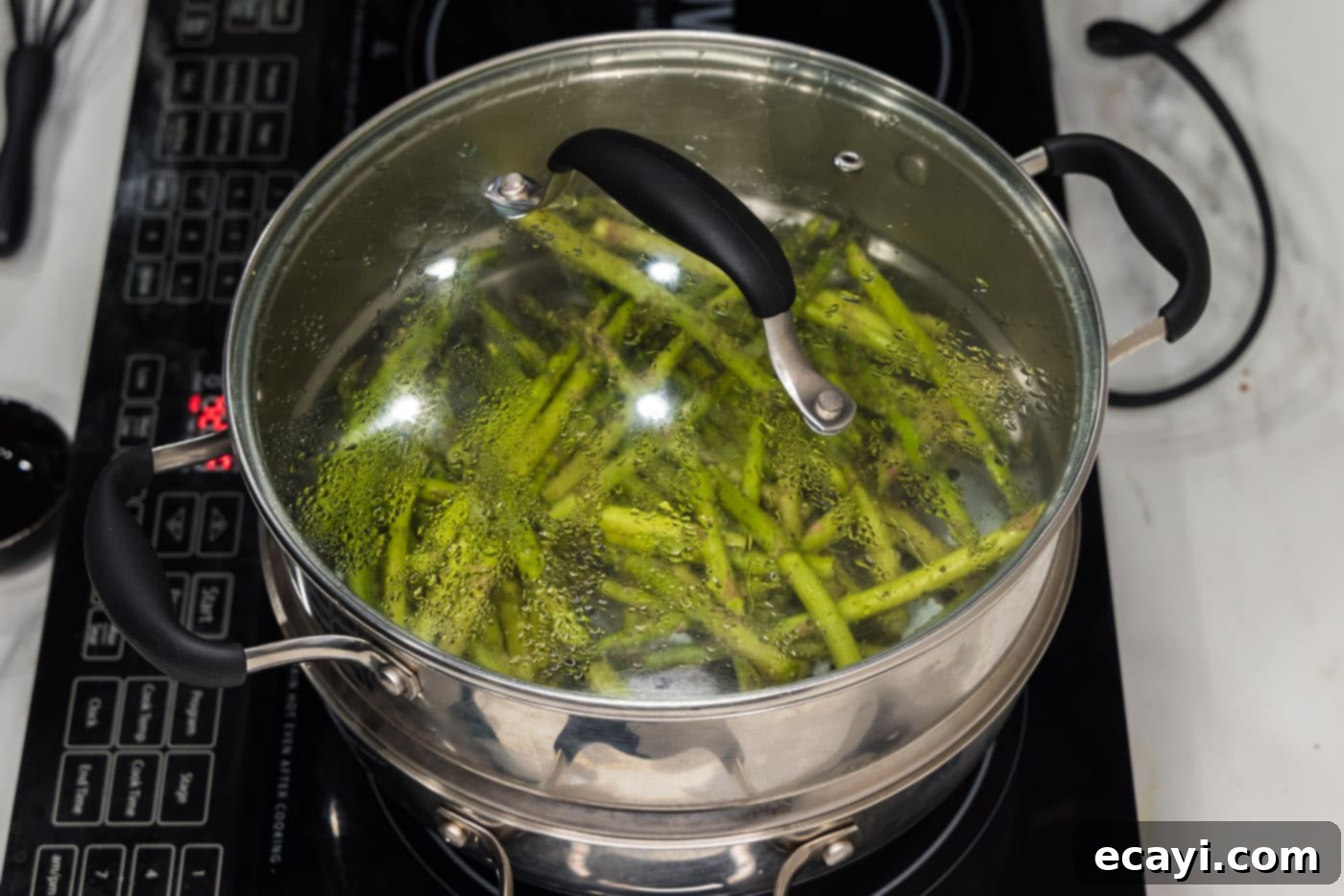 Perfectly Steamed Asparagus 7 Lid covering asparagus spears in a steam pot, actively steaming