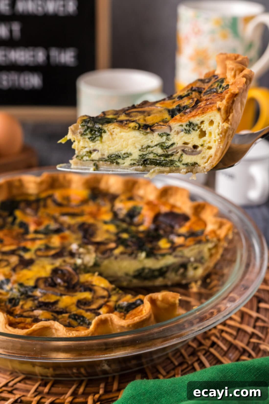 Savory Spinach Mushroom Quiche 2 Slice of Spinach Mushroom Quiche being lifted out of the pie plate, showcasing its golden crust and vibrant filling.