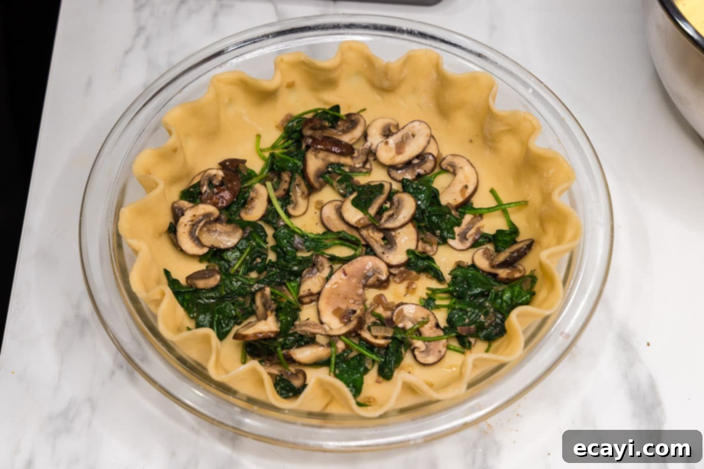 Savory Spinach Mushroom Quiche 11 Half of the sautéed mushroom and spinach mixture layered inside the unbaked pie crust.