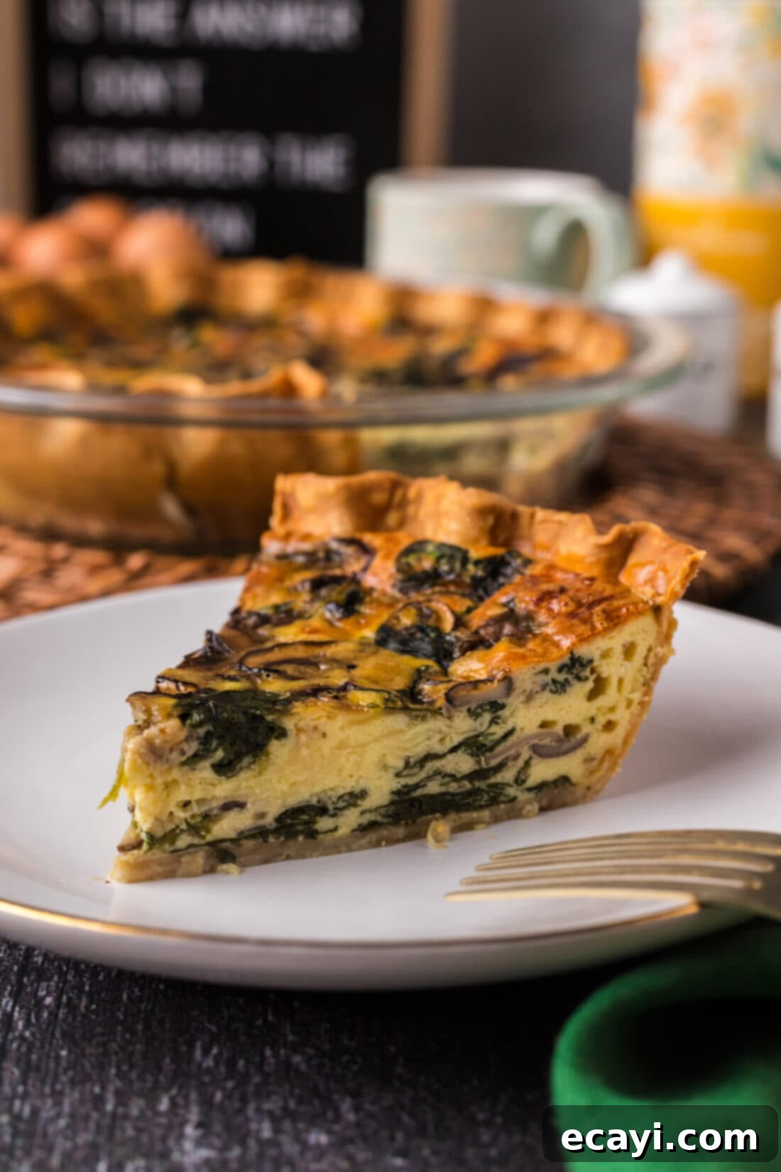 Savory Spinach Mushroom Quiche 14 A perfectly sliced piece of Spinach Mushroom Quiche on a white plate, revealing its creamy texture and filling.