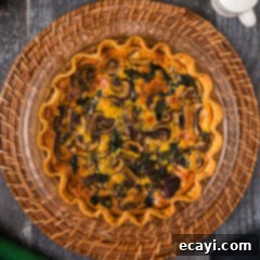 Savory Spinach Mushroom Quiche 15 Overhead photo of a Spinach Mushroom Quiche, freshly baked and golden.