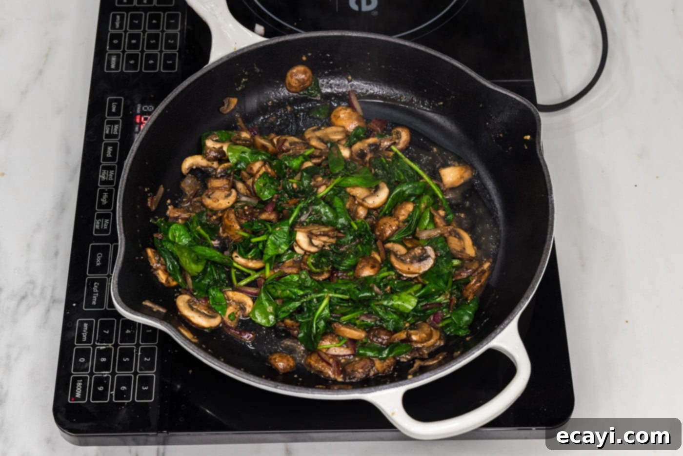 Savory Spinach Mushroom Quiche 8 Cooked down spinach and mushrooms in a skillet, looking tender and ready for the quiche filling.