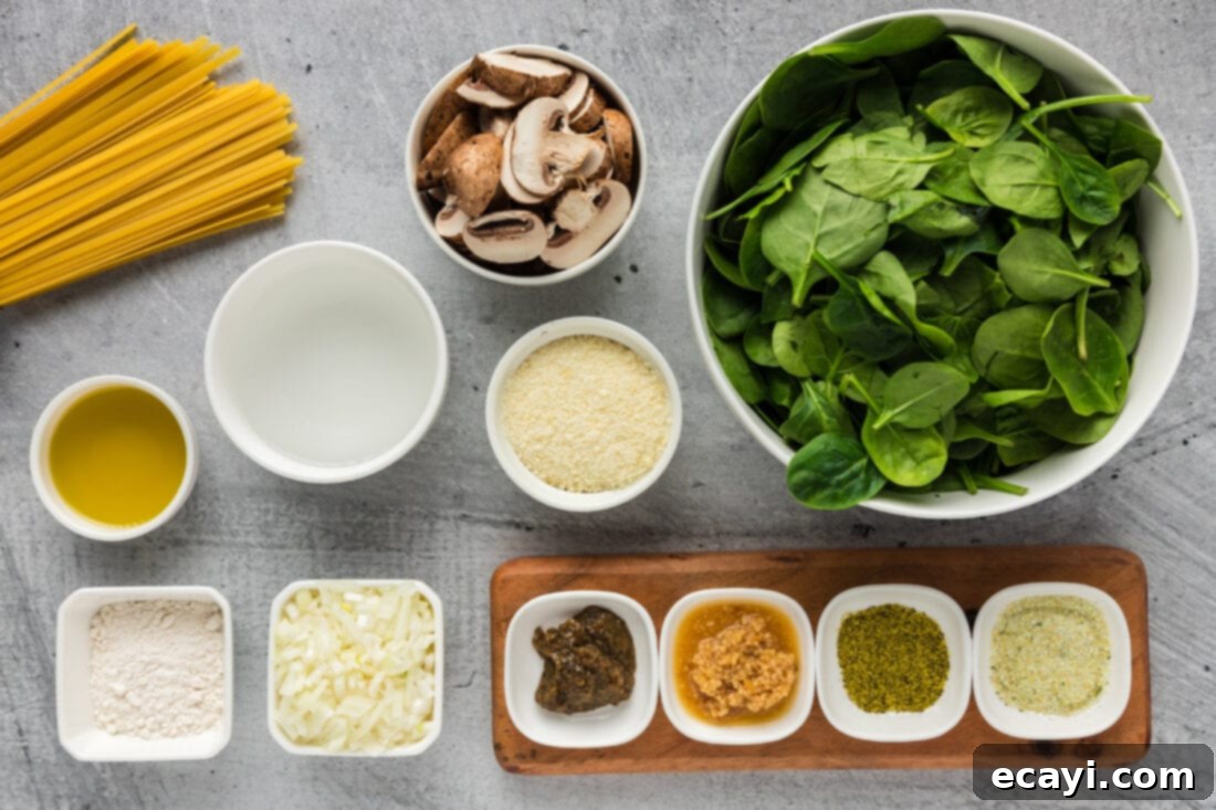 Vibrant Spinach Fettuccine 4 Fresh ingredients laid out for Spinach Fettuccine, including vibrant spinach, sliced mushrooms, garlic, and onion