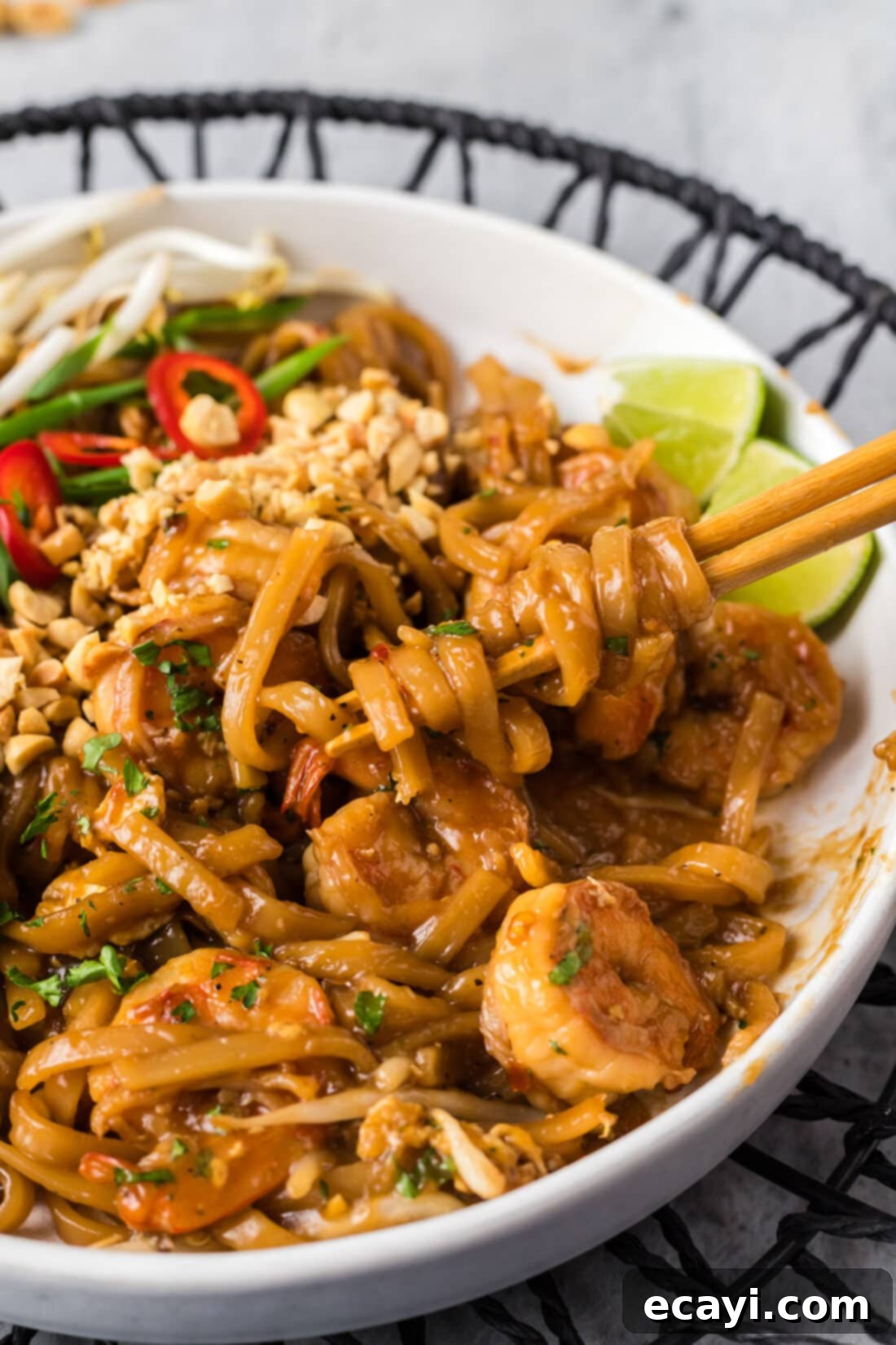Authentic Shrimp Pad Thai 12 Pad Thai noodles gracefully wrapped around chopsticks, ready to be enjoyed