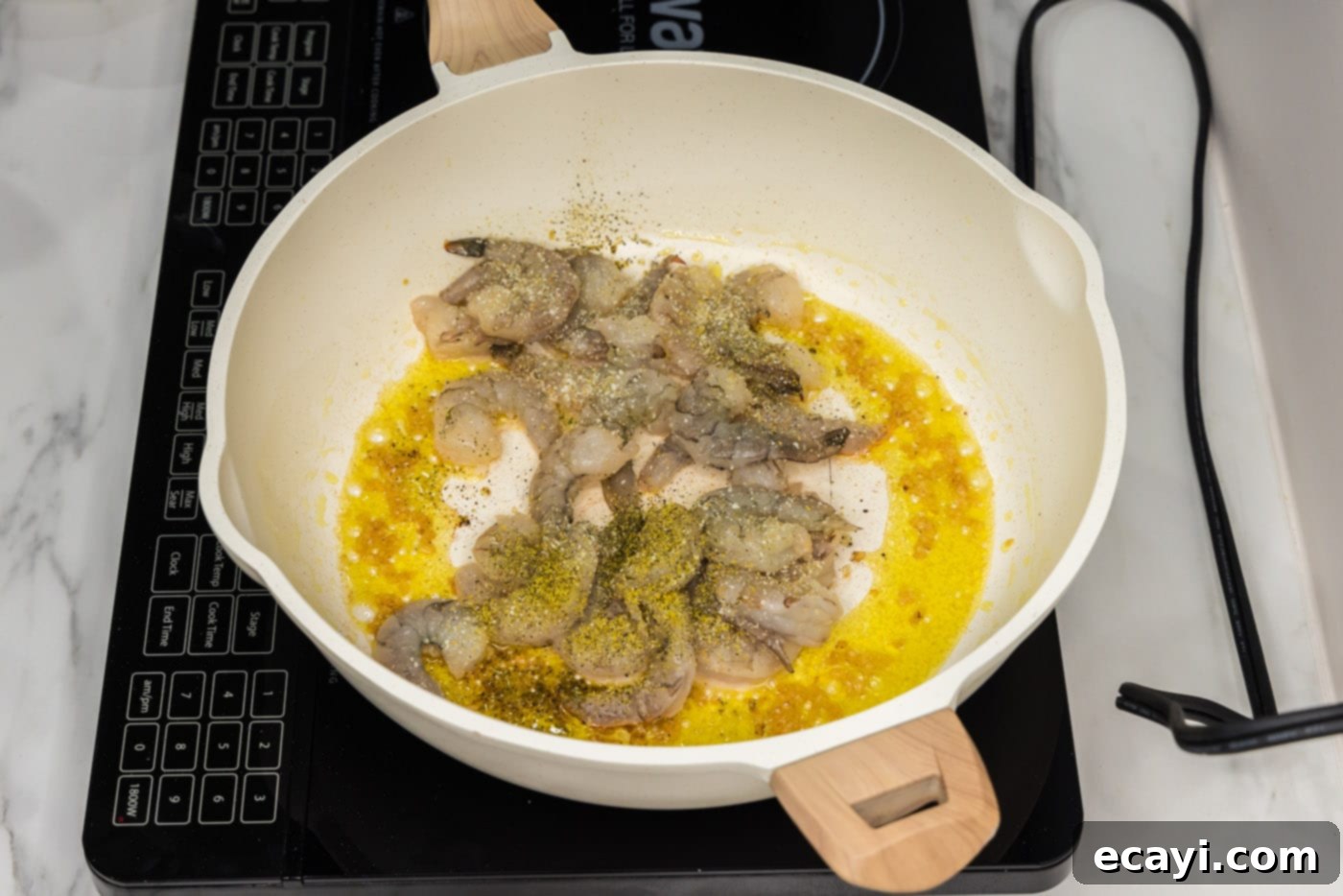 Authentic Shrimp Pad Thai 6 Raw shrimp cooking in a skillet with olive oil and minced garlic