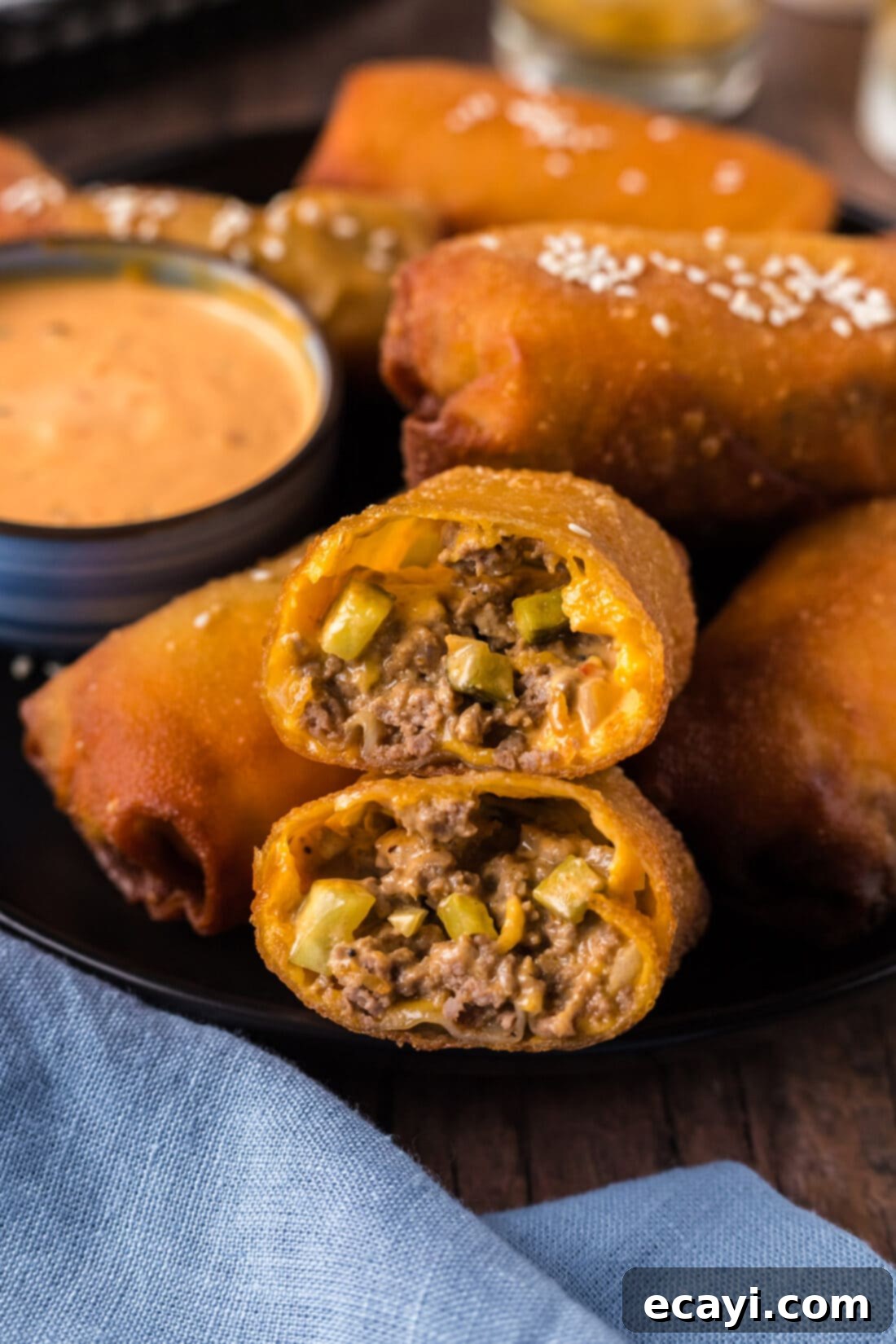 Ultimate Big Mac Egg Rolls 2 Close up photo of a Big Mac Egg Roll cut in half stacked on top of each other, showcasing the savory filling and crispy wrapper