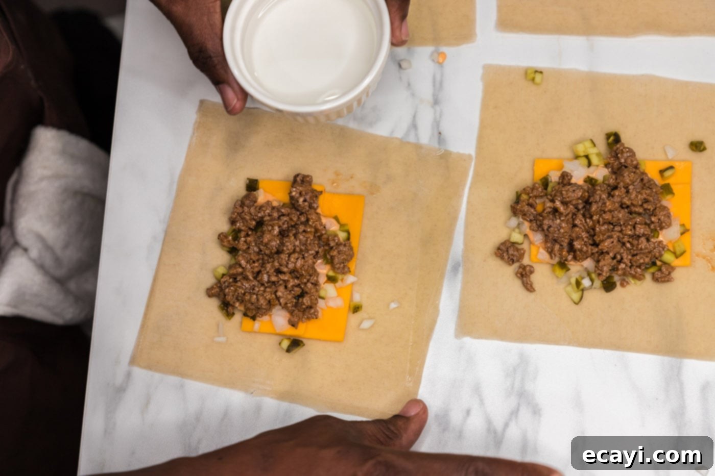 Ultimate Big Mac Egg Rolls 11 using a wet finger to moisten the edges of an egg roll wrapper for sealing