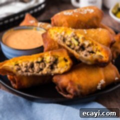 Ultimate Big Mac Egg Rolls 17 Big Mac Egg Roll cut in half resting on other Big Mac Egg Rolls, showing the delicious filling