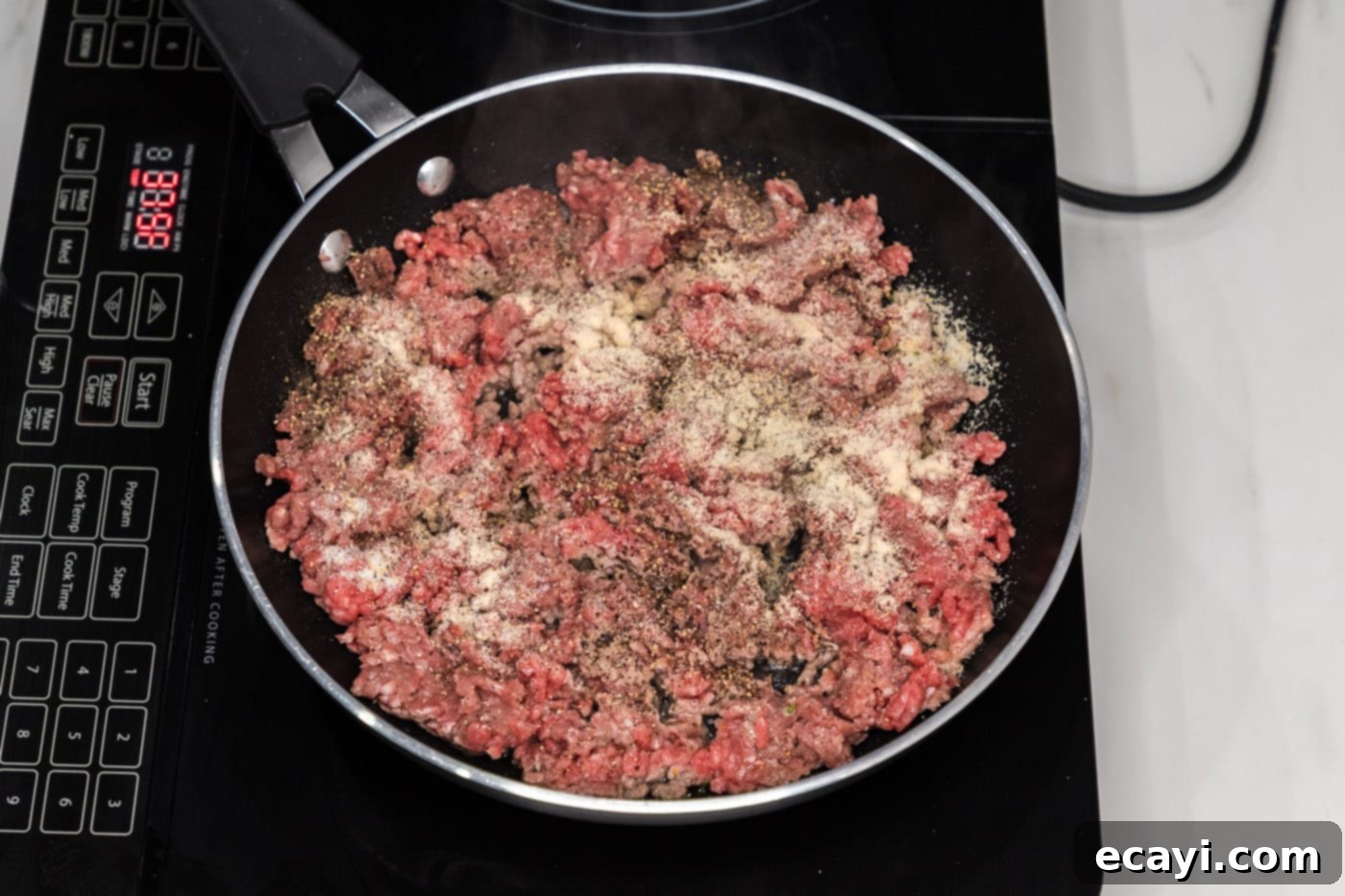 Ultimate Big Mac Egg Rolls 5 ground beef in a skillet with seasonings, ready for browning